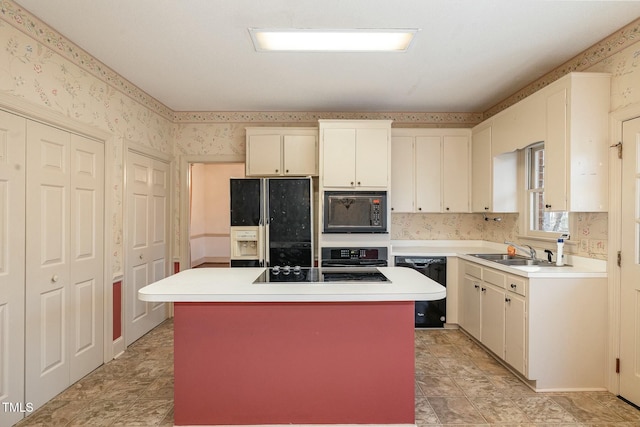 kitchen with white cabinetry, a kitchen island, sink, and black appliances