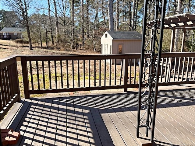 deck featuring a shed and a pergola