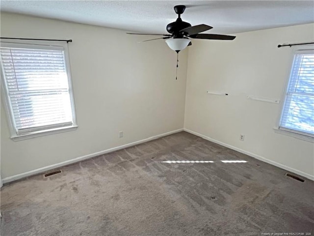 spare room with ceiling fan, a healthy amount of sunlight, and carpet floors