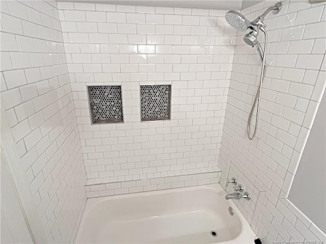 bathroom featuring tiled shower / bath