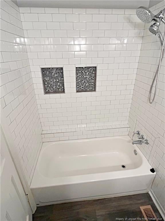 bathroom featuring hardwood / wood-style flooring and tiled shower / bath