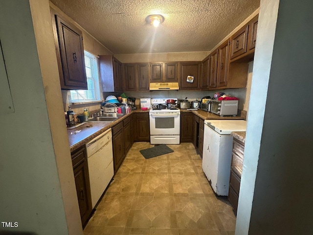 kitchen with sink, a textured ceiling, and white appliances