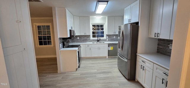 kitchen featuring sink, dishwasher, white cabinetry, electric range, and stainless steel refrigerator with ice dispenser