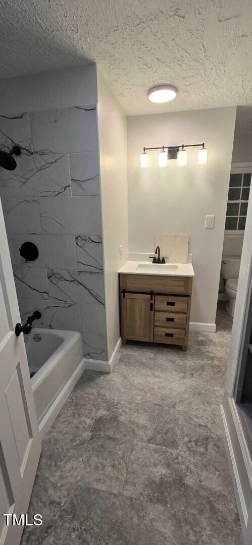 full bathroom with tiled shower / bath, vanity, toilet, and a textured ceiling