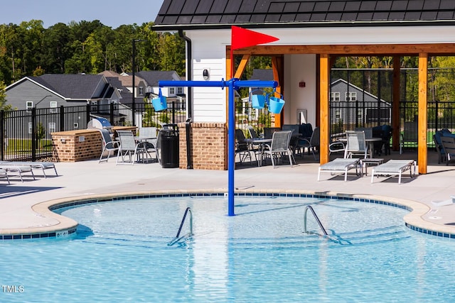 view of pool with a patio area and a playground