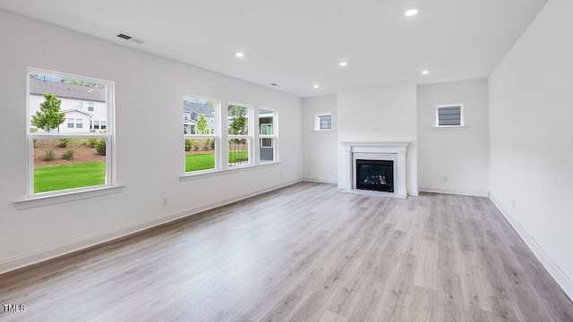 1705 Clydner Dr, Cary, NC 27523 - unfurnished living room with healthy amount of natural light, light wood-type flooring, a fireplace, and recessed lighting
