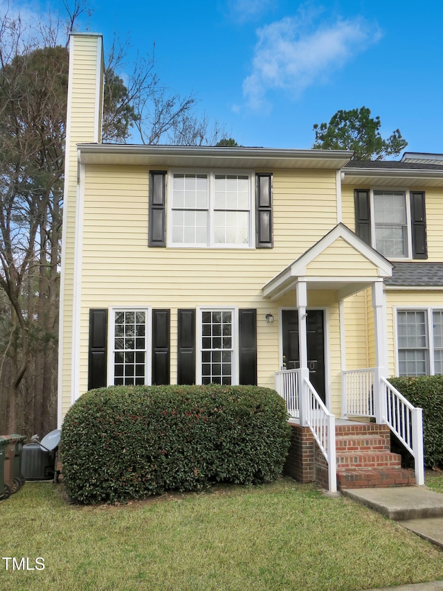 130 Luxon Pl, Cary, NC 27513 - traditional home featuring a chimney, central air condition unit, and a front lawn