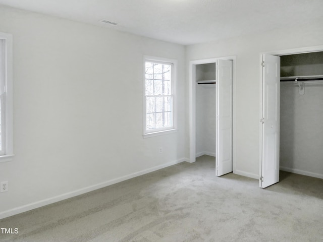 130 Luxon Pl, Cary, NC 27513 - unfurnished bedroom with baseboards, multiple closets, visible vents, and carpet