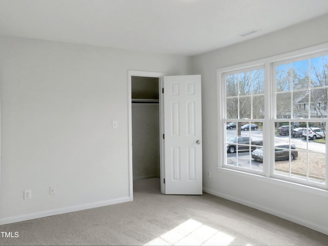 130 Luxon Pl, Cary, NC 27513 - unfurnished bedroom with a walk in closet, baseboards, visible vents, light carpet, and a closet