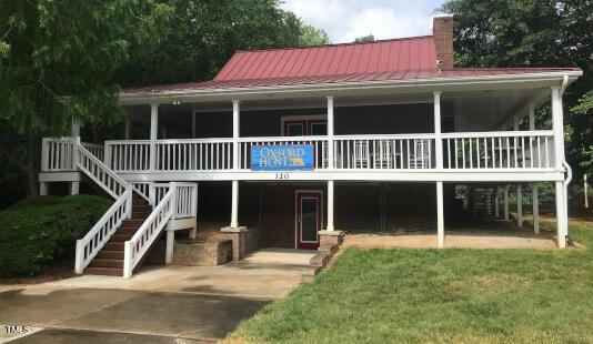 130 Luxon Pl, Cary, NC 27513 - view of front of house with a front yard, a standing seam roof, stairway, a chimney, and metal roof