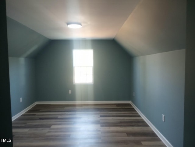 bonus room with vaulted ceiling and dark hardwood / wood-style floors