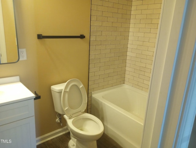 bathroom featuring baseboards, toilet, wood finished floors, and vanity