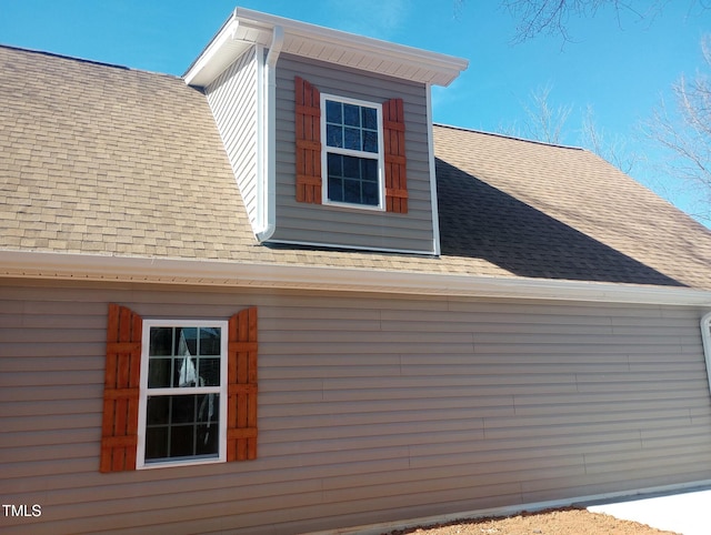 view of side of property featuring a shingled roof