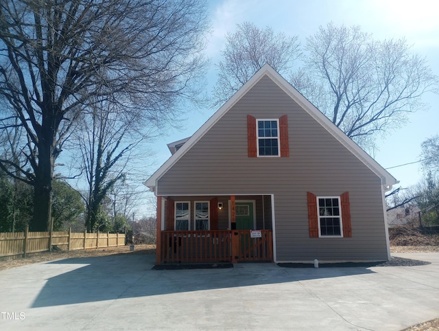 view of front of home featuring a porch and fence