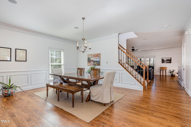 dining area featuring crown molding, ceiling fan with notable chandelier, and light hardwood / wood-style floors