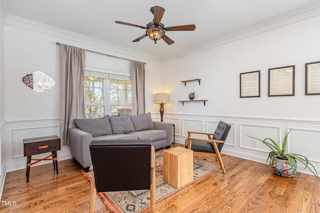 living room featuring ornamental molding, light hardwood / wood-style floors, and ceiling fan