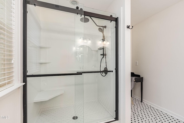 full bathroom with a shower stall and baseboards