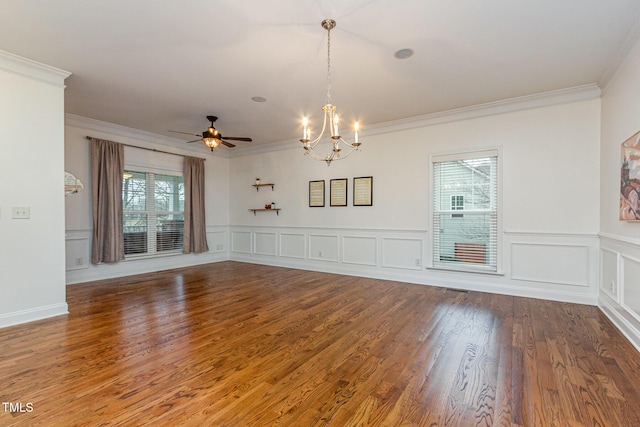 spare room featuring ornamental molding, ceiling fan with notable chandelier, a decorative wall, and wood finished floors