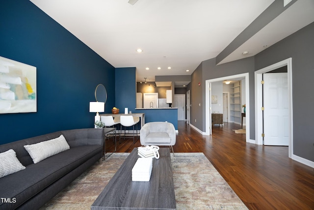 living room with baseboards, dark wood-type flooring, and recessed lighting