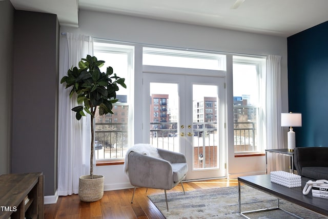 interior space with french doors, wood finished floors, and baseboards