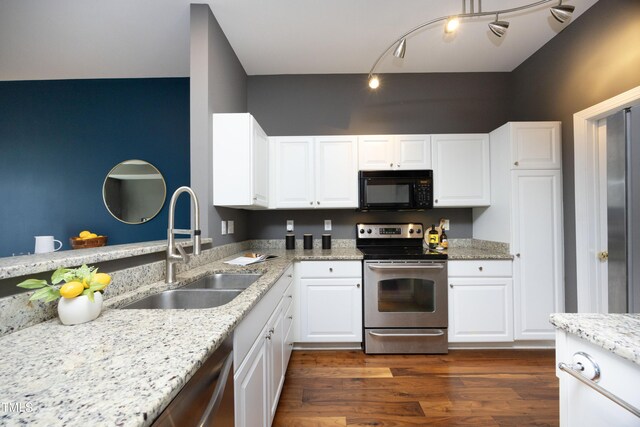 kitchen featuring dark wood-style floors, appliances with stainless steel finishes, light stone counters, white cabinetry, and a sink