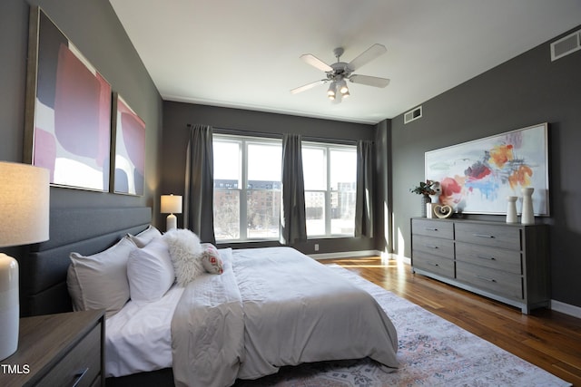 bedroom featuring baseboards, visible vents, ceiling fan, and dark wood-style flooring