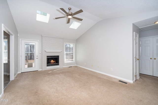 unfurnished living room with ceiling fan, light colored carpet, a fireplace, and vaulted ceiling