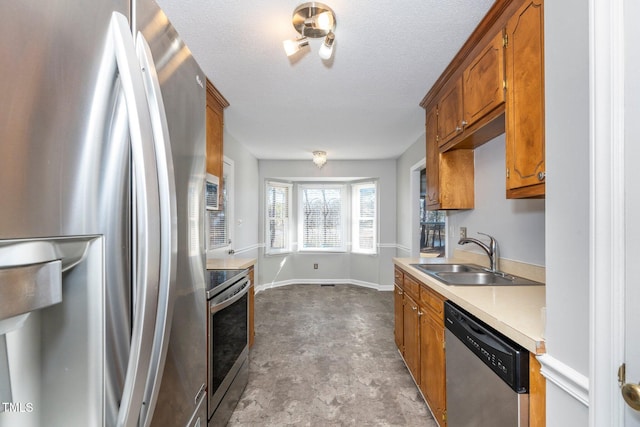 kitchen with sink, stainless steel appliances, and a textured ceiling