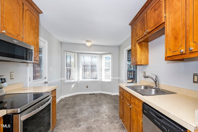 kitchen featuring sink, stainless steel appliances, and a textured ceiling