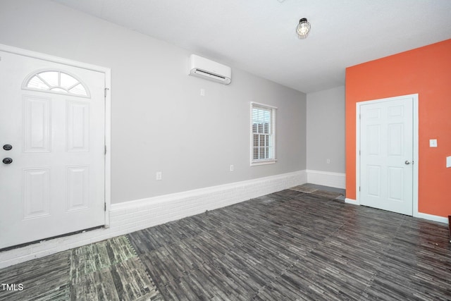 foyer entrance featuring a wall mounted air conditioner and dark wood-type flooring