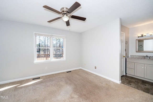 spare room featuring ceiling fan, light colored carpet, and sink