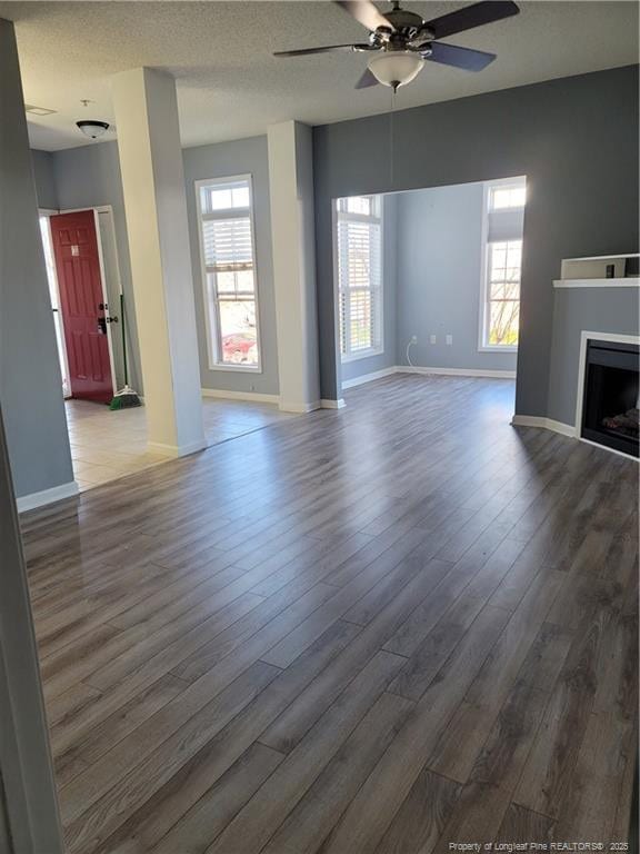 unfurnished living room featuring a healthy amount of sunlight, hardwood / wood-style floors, and ceiling fan