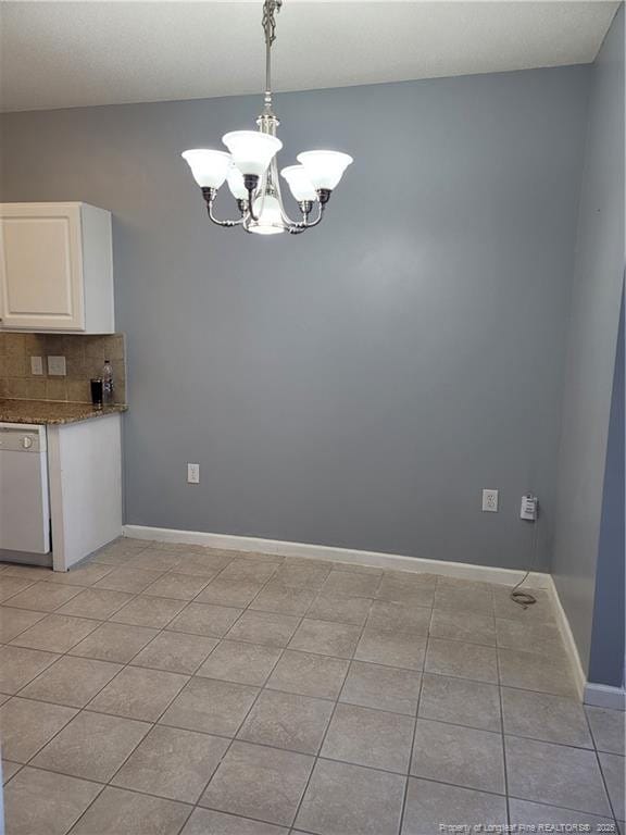 unfurnished dining area with light tile patterned floors and a chandelier