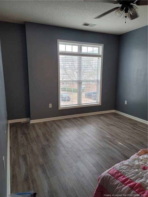 interior space featuring ceiling fan, a textured ceiling, and dark hardwood / wood-style flooring