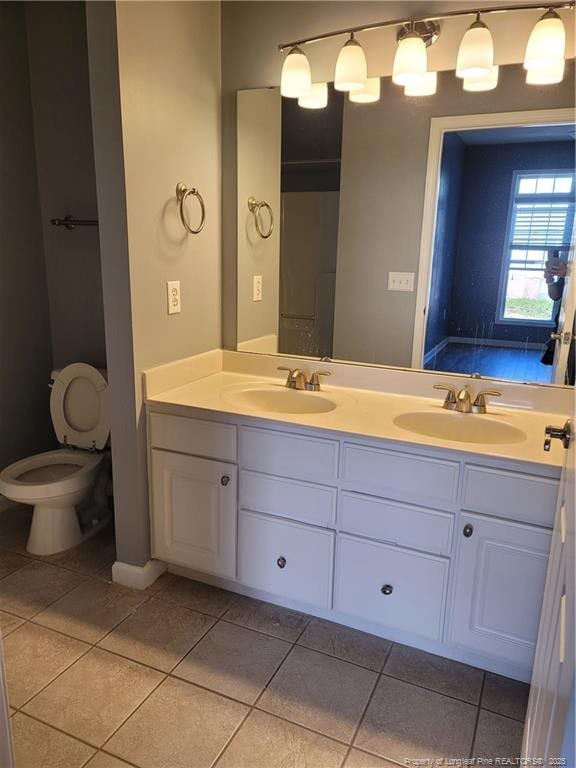 bathroom featuring vanity, tile patterned floors, and toilet