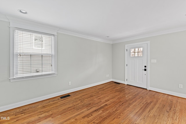 entrance foyer with crown molding, a wealth of natural light, and light wood-type flooring