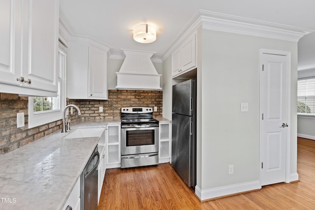 kitchen featuring stainless steel appliances, white cabinetry, custom range hood, and crown molding