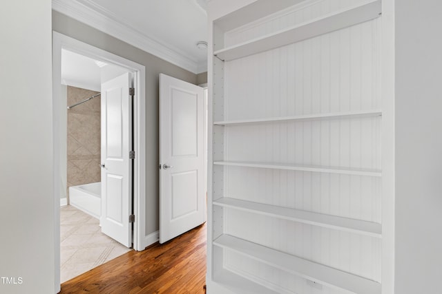 corridor with hardwood / wood-style flooring and crown molding