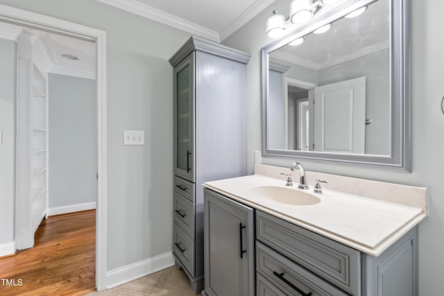 bathroom with hardwood / wood-style flooring, ornamental molding, and vanity