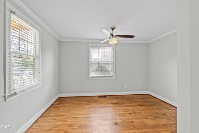 spare room featuring crown molding, plenty of natural light, and light hardwood / wood-style floors