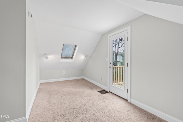 bonus room with carpet flooring and lofted ceiling with skylight