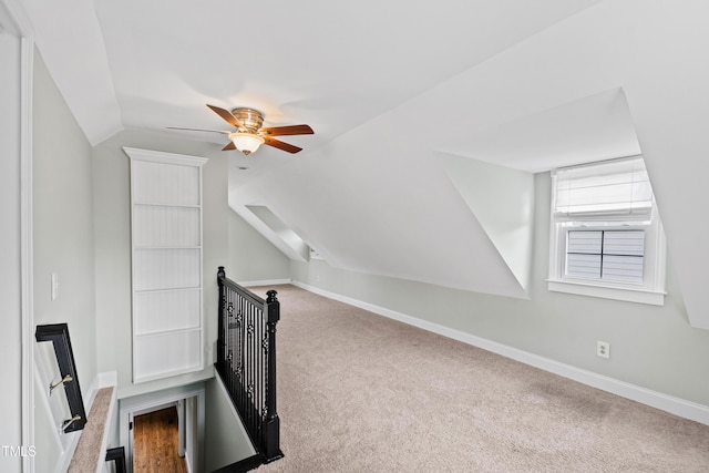 interior space with vaulted ceiling, carpet flooring, and ceiling fan