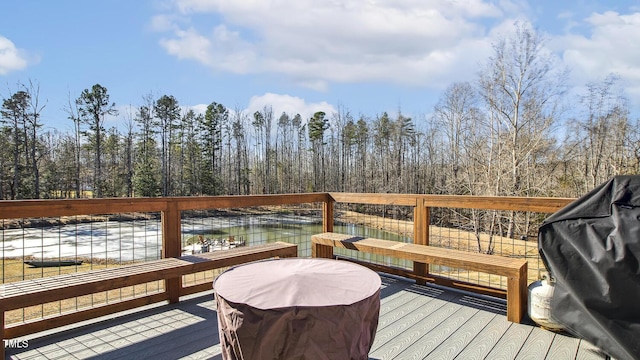 deck with a water view and area for grilling