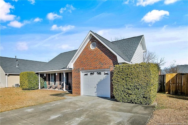 view of front of house featuring a garage, a porch, cooling unit, and a front lawn