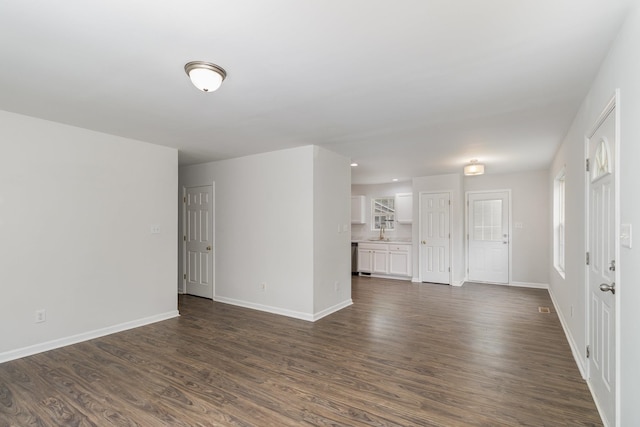 spare room with sink and dark wood-type flooring