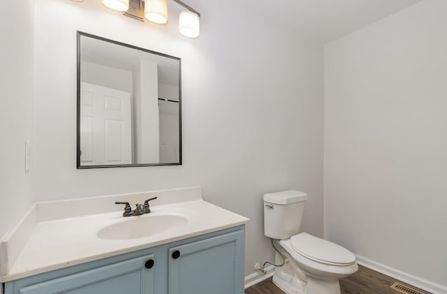 bathroom featuring vanity, hardwood / wood-style flooring, and toilet