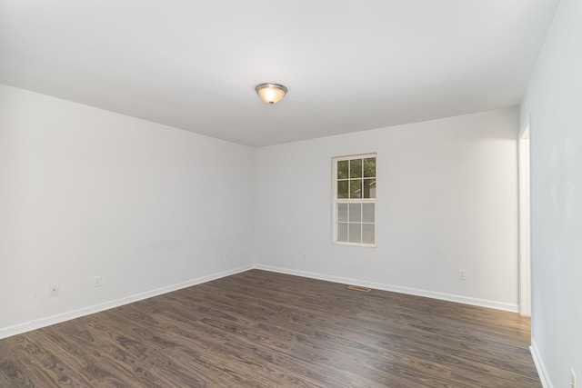 spare room with dark wood-type flooring