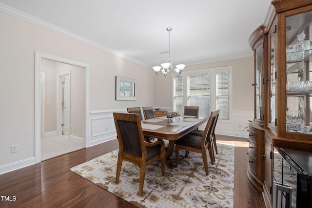 dining area with ornamental molding, wood finished floors, and wainscoting