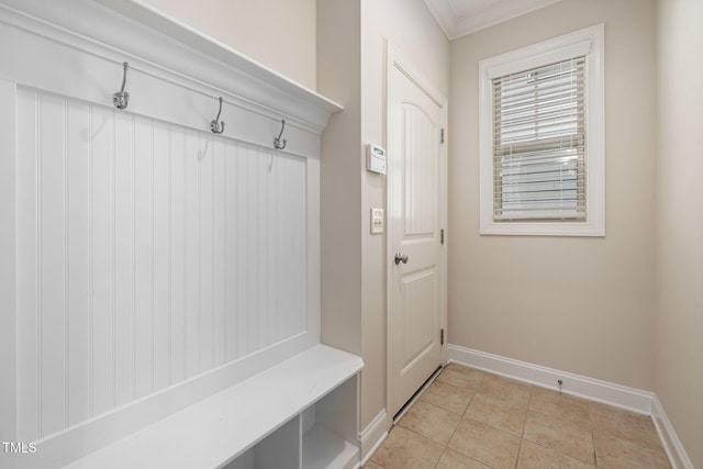 mudroom with crown molding, baseboards, and light tile patterned floors