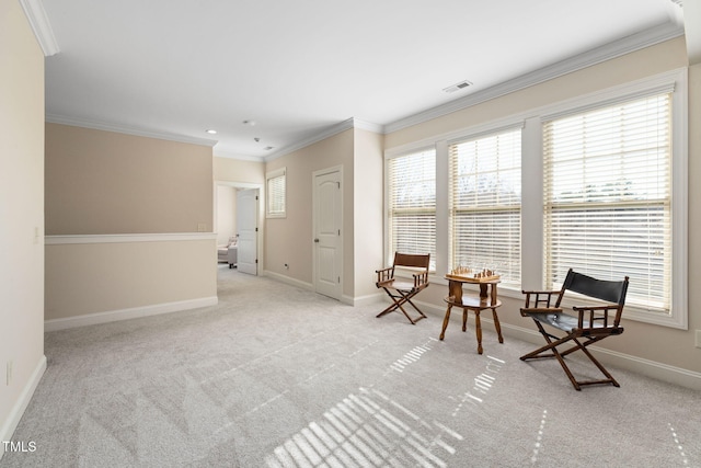 sitting room with visible vents, baseboards, crown molding, and carpet flooring